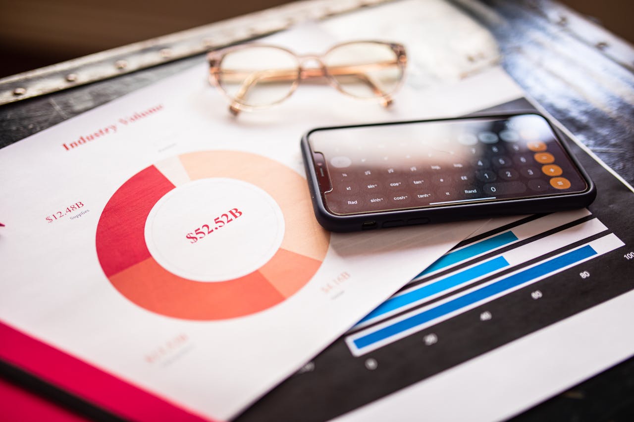 mobile-01 Smartphone on business documents with charts and graphs, illustrating financial analysis.